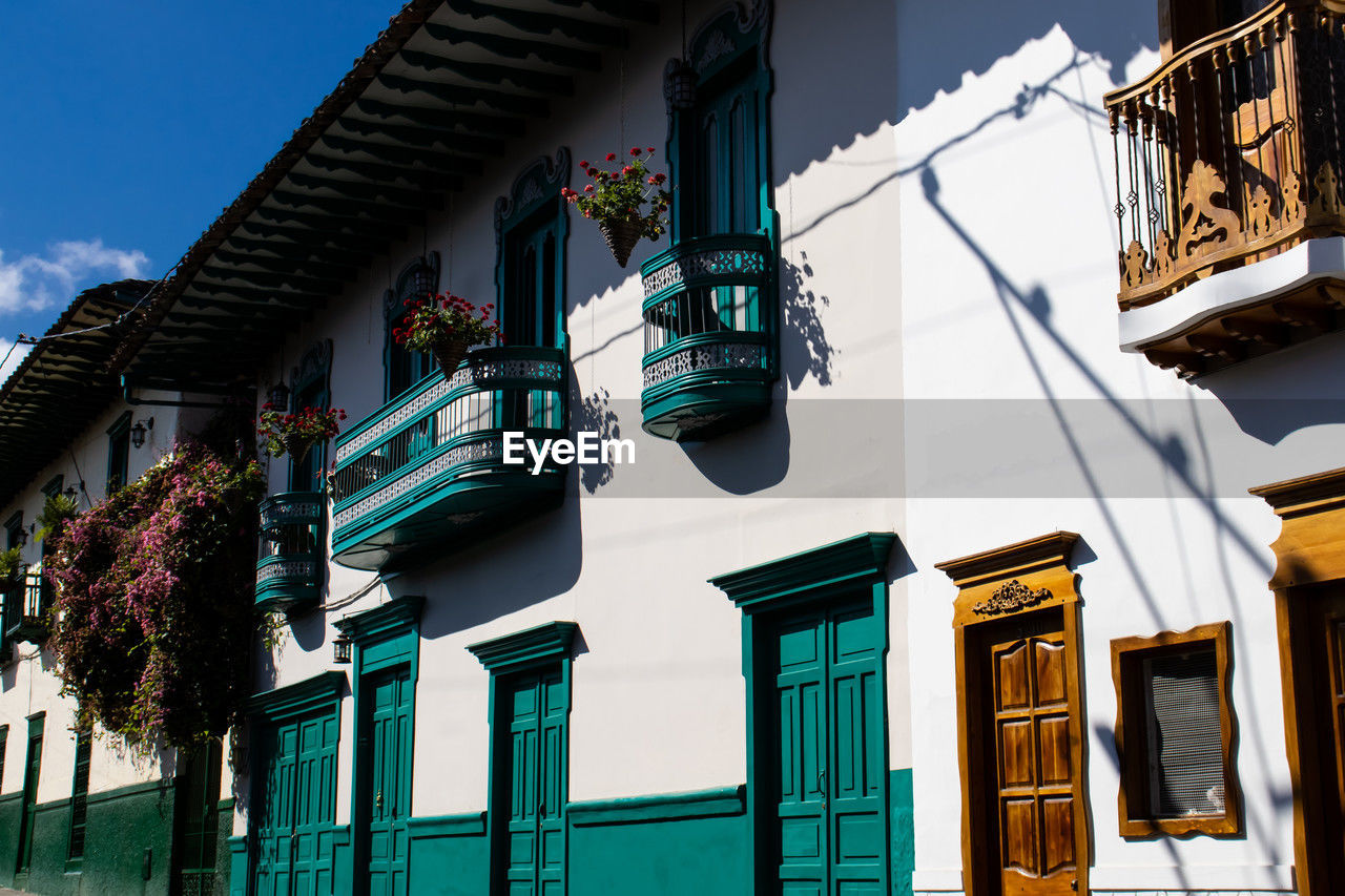 architecture, building exterior, built structure, urban area, building, city, nature, house, facade, residential district, street, no people, sky, road, neighbourhood, low angle view, window, downtown, town, blue, travel destinations, outdoors, day