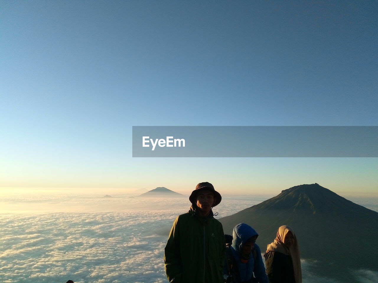 PEOPLE ON MOUNTAIN AGAINST CLEAR BLUE SKY