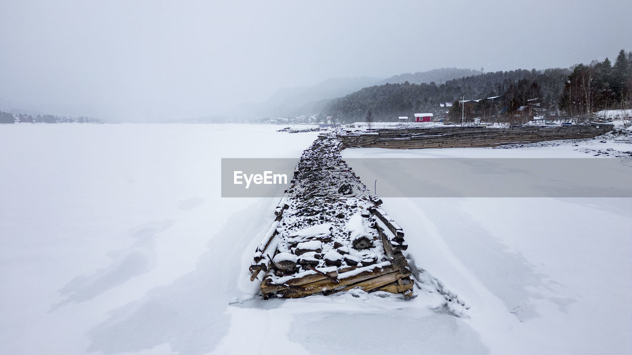snow, cold temperature, winter, environment, scenics - nature, landscape, nature, beauty in nature, mountain, tree, water, land, travel, tranquility, sky, frozen, tranquil scene, travel destinations, forest, no people, freezing, non-urban scene, vehicle, polar climate, day, pinaceae, holiday, tourism, outdoors, coniferous tree, fog, blizzard, vacation, rural scene, white, trip, snowcapped mountain, transportation, plant, ice, winter storm