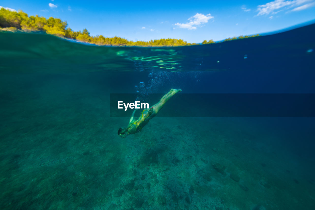 Girl diving in the adriatic sea on hvar island, croatia