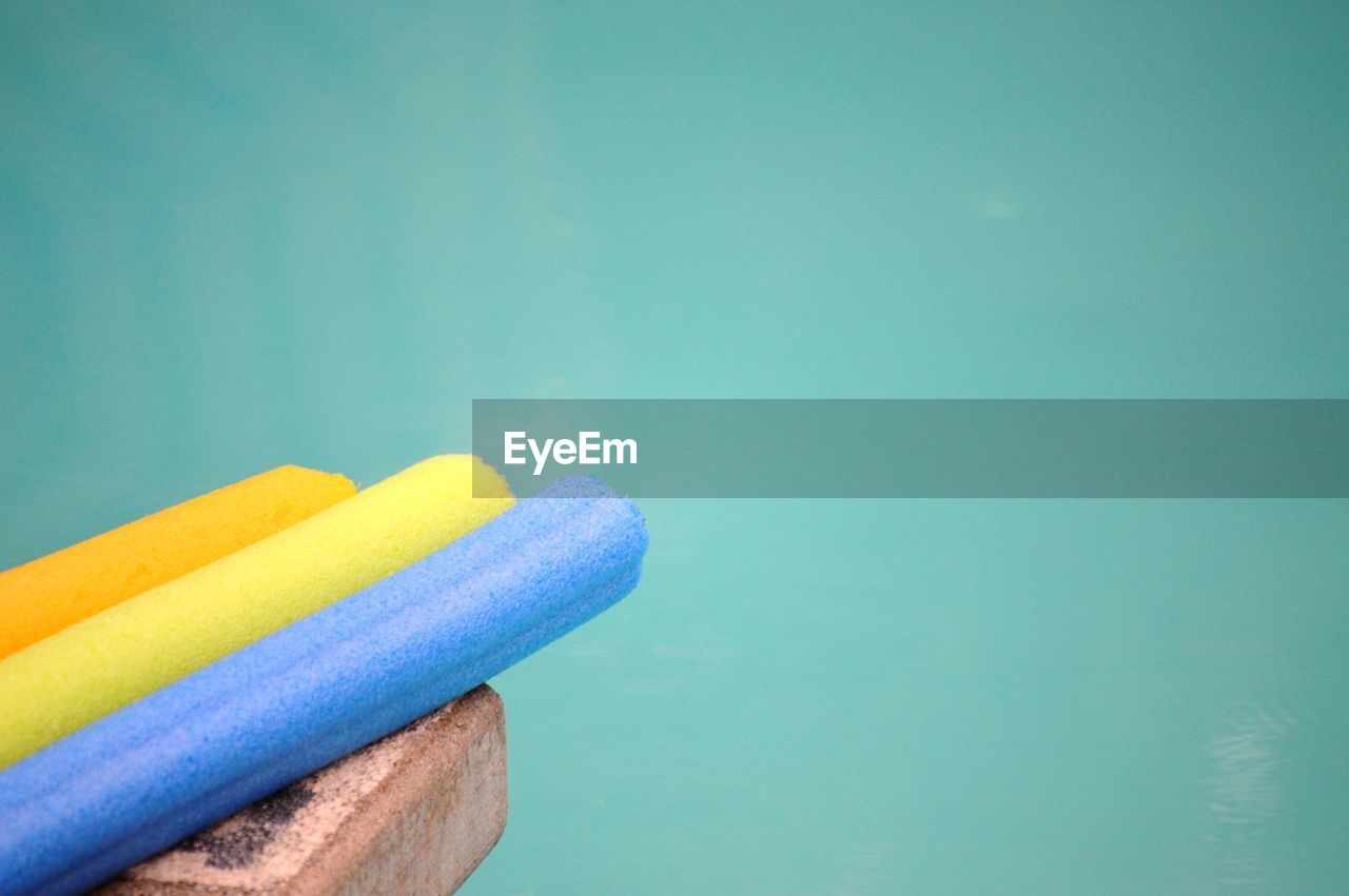 Close-up of colorful sponge by colored background