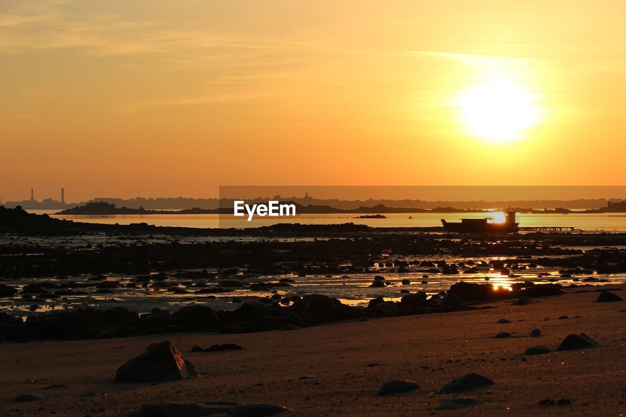 Scenic view of beach against sky during sunset