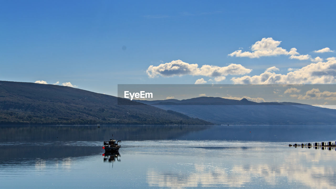 Scenic view of boat in loch fyne against sky