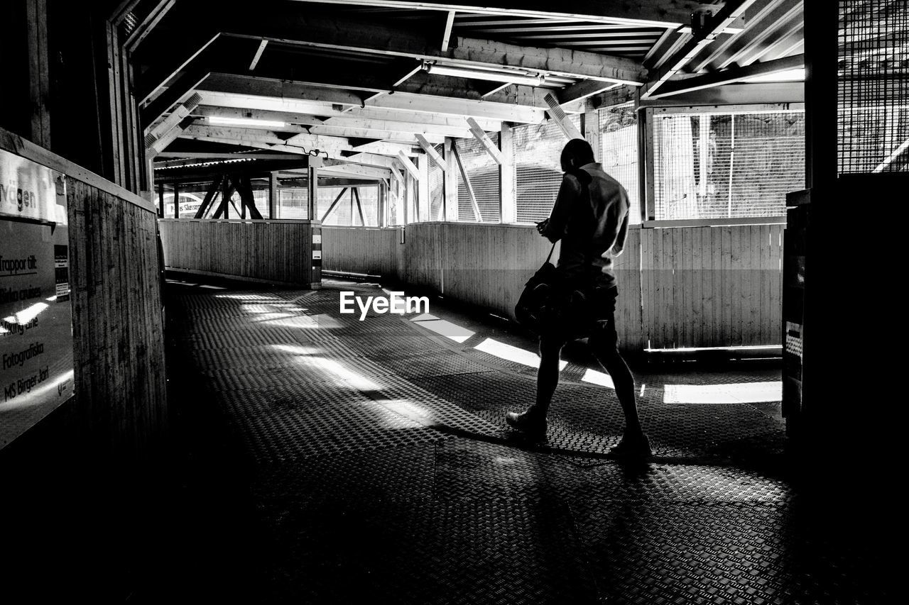 FULL LENGTH REAR VIEW OF MAN WALKING IN SUBWAY