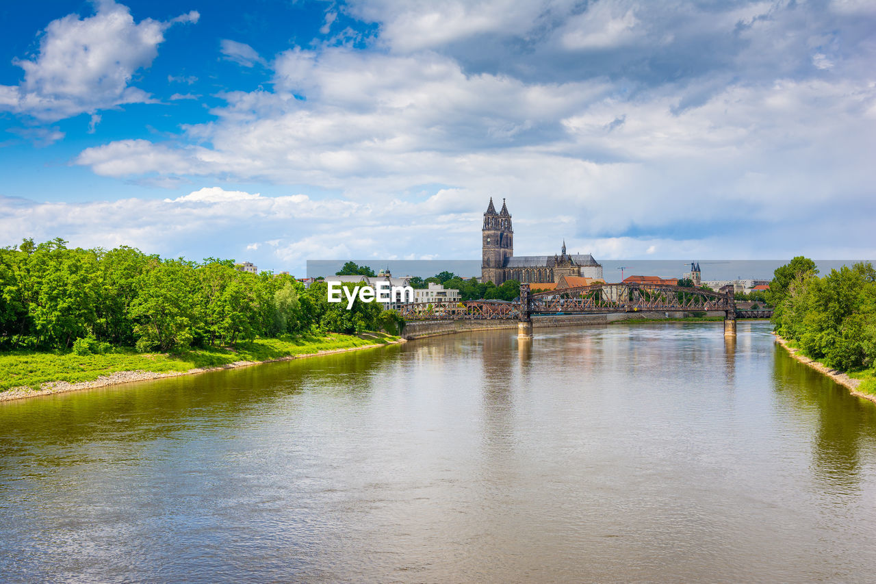 VIEW OF RIVER AMIDST BUILDINGS AGAINST SKY