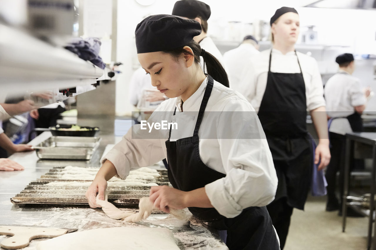 Chef baking baguette in commercial kitchen