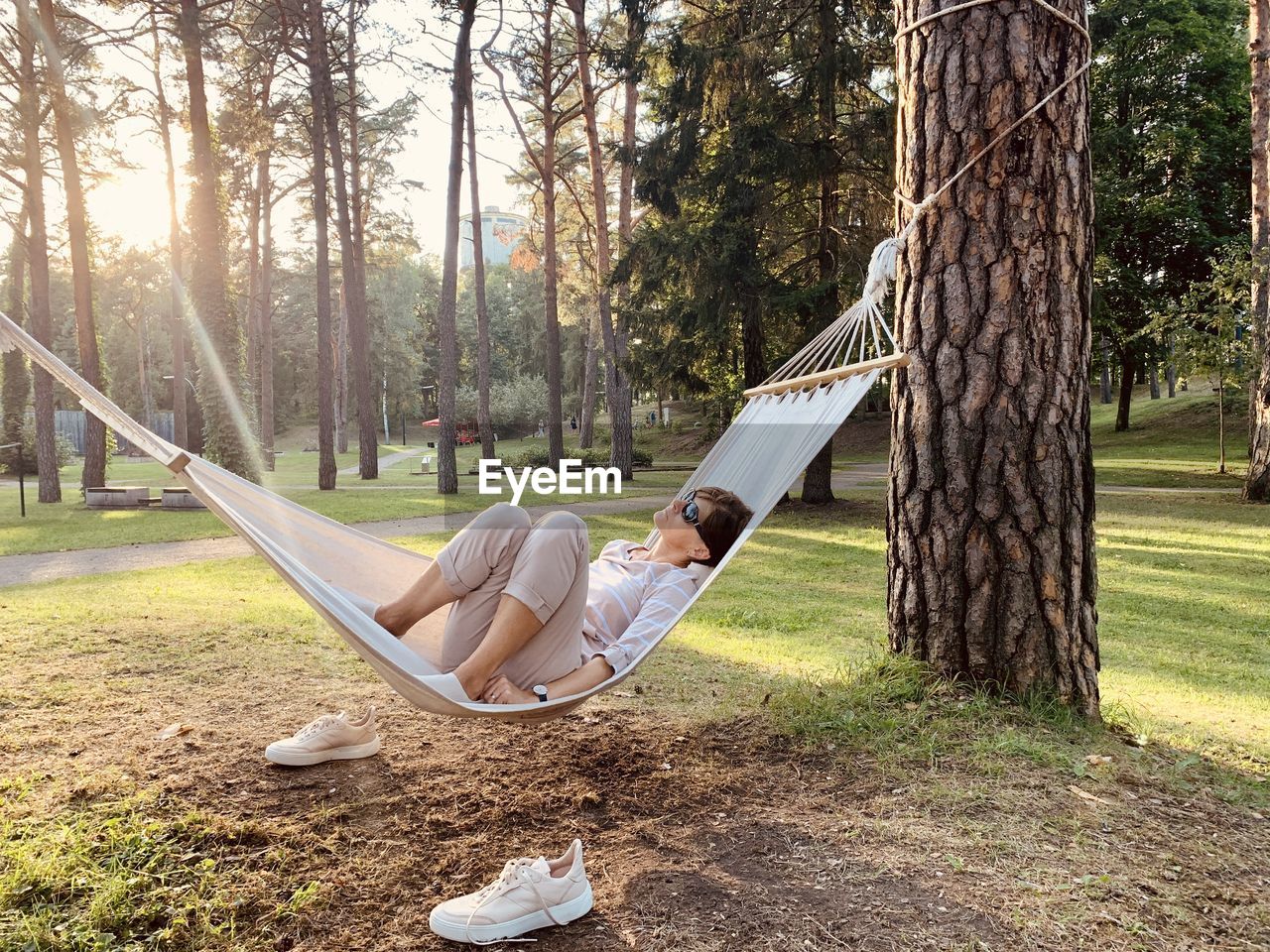 Lonely woman lying in hammock in warm summer evening