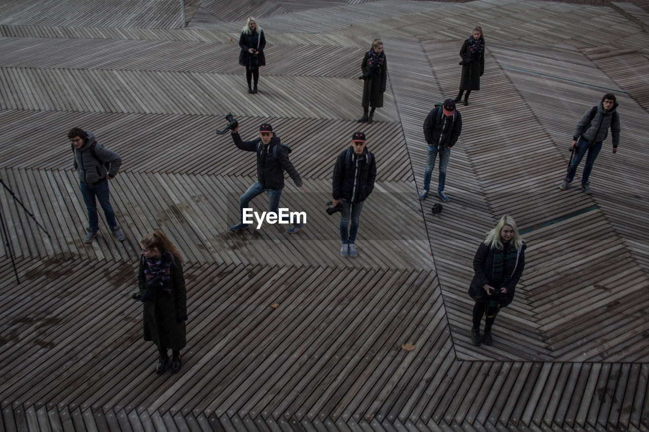 HIGH ANGLE VIEW OF PEOPLE WALKING ON ZEBRA CROSSING