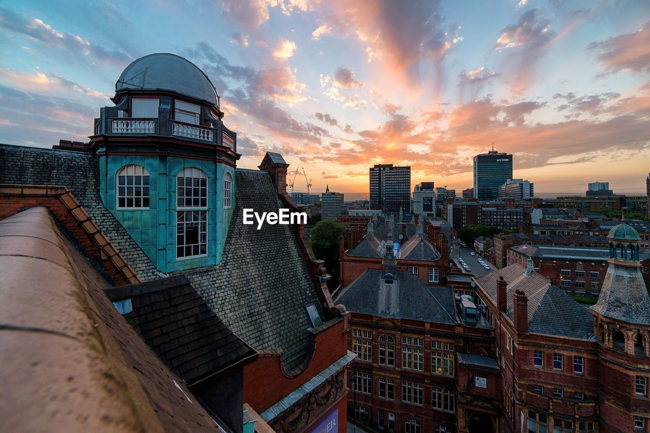 High angle view of buildings against cloudy sky at sunset