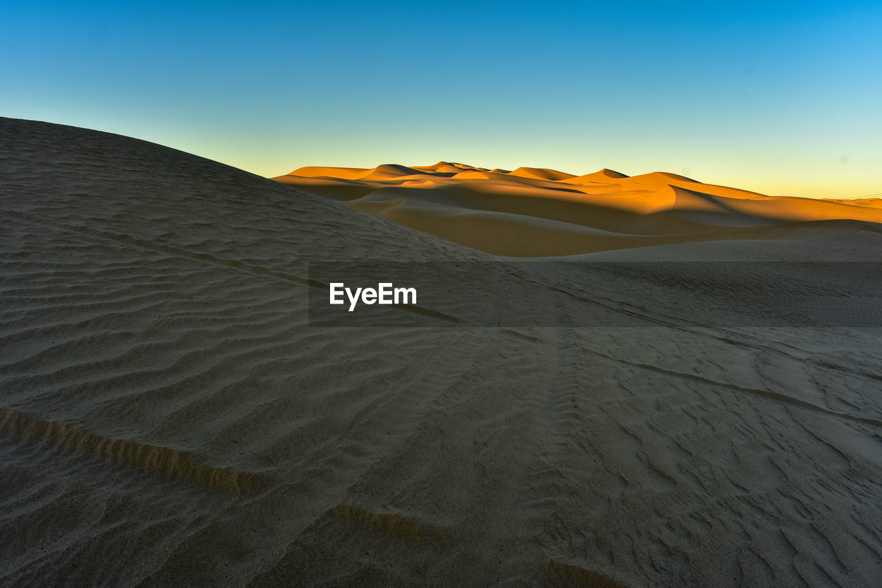 Scenic view of desert against sky during sunset