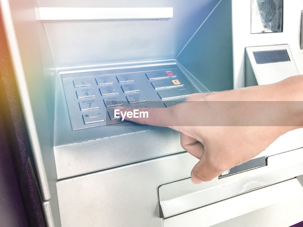 Close-up of hand touching atm keypad