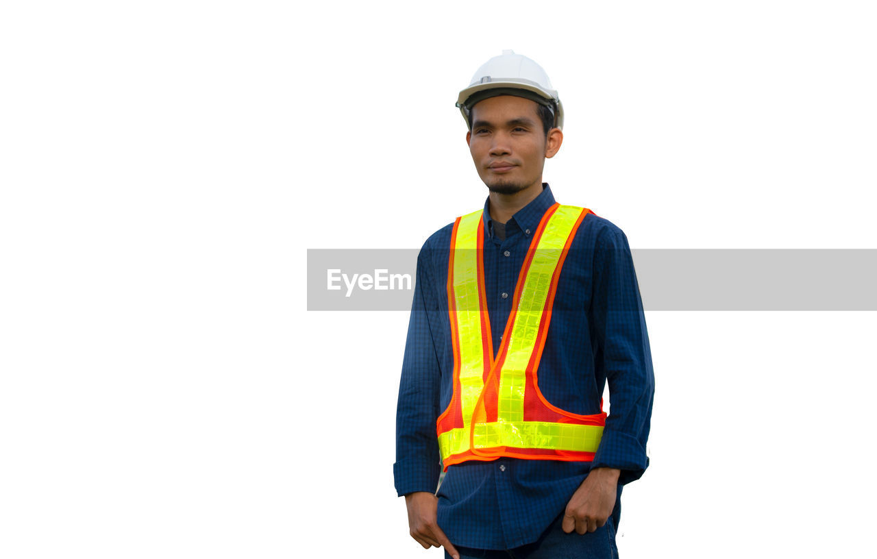 PORTRAIT OF YOUNG MAN STANDING OVER WHITE BACKGROUND