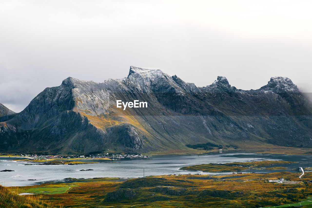 Scenic view of lake by mountain against sky