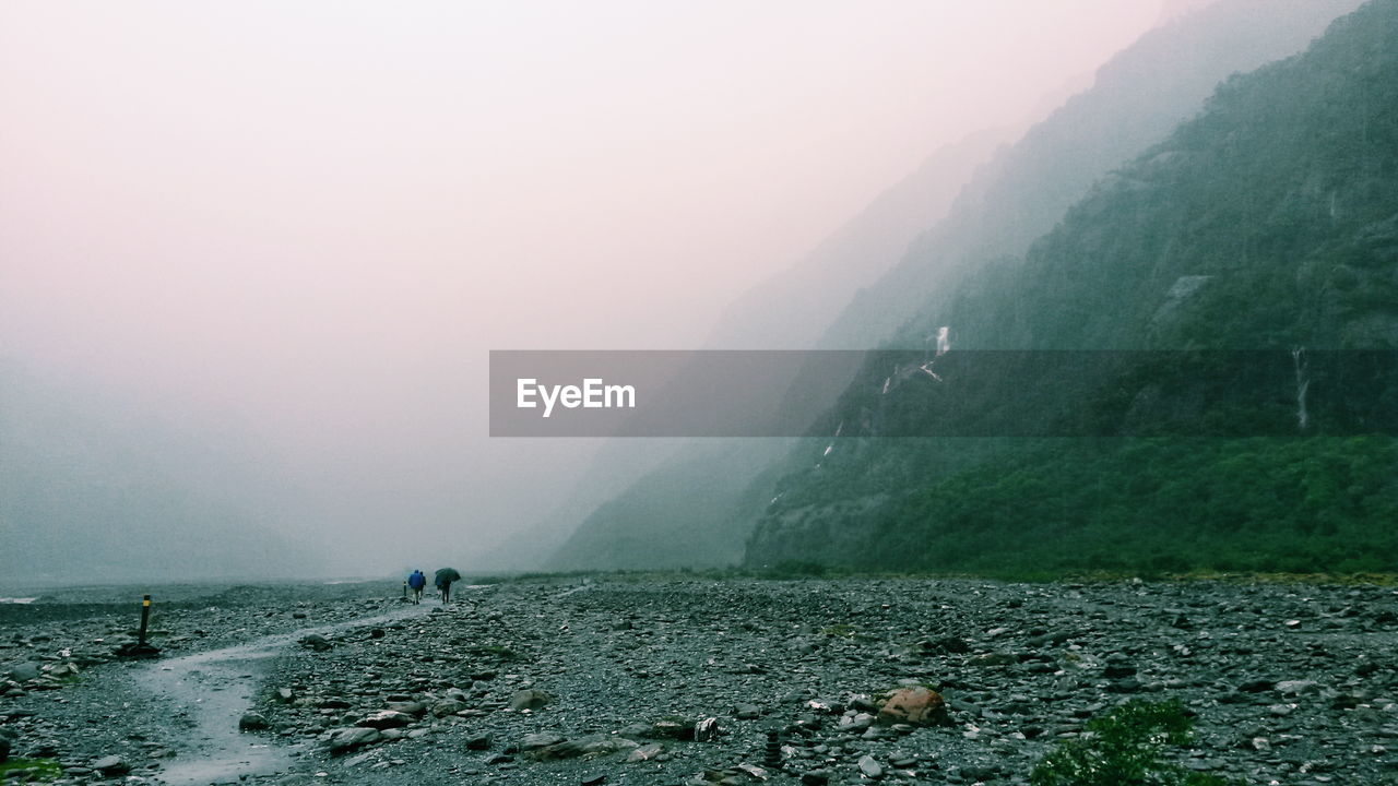 SCENIC VIEW OF MOUNTAINS AGAINST SKY DURING RAINY DAY