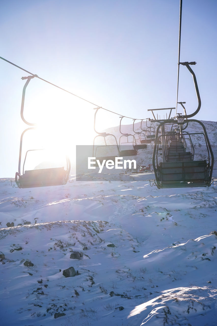 SKI LIFT OVER SNOW COVERED LANDSCAPE