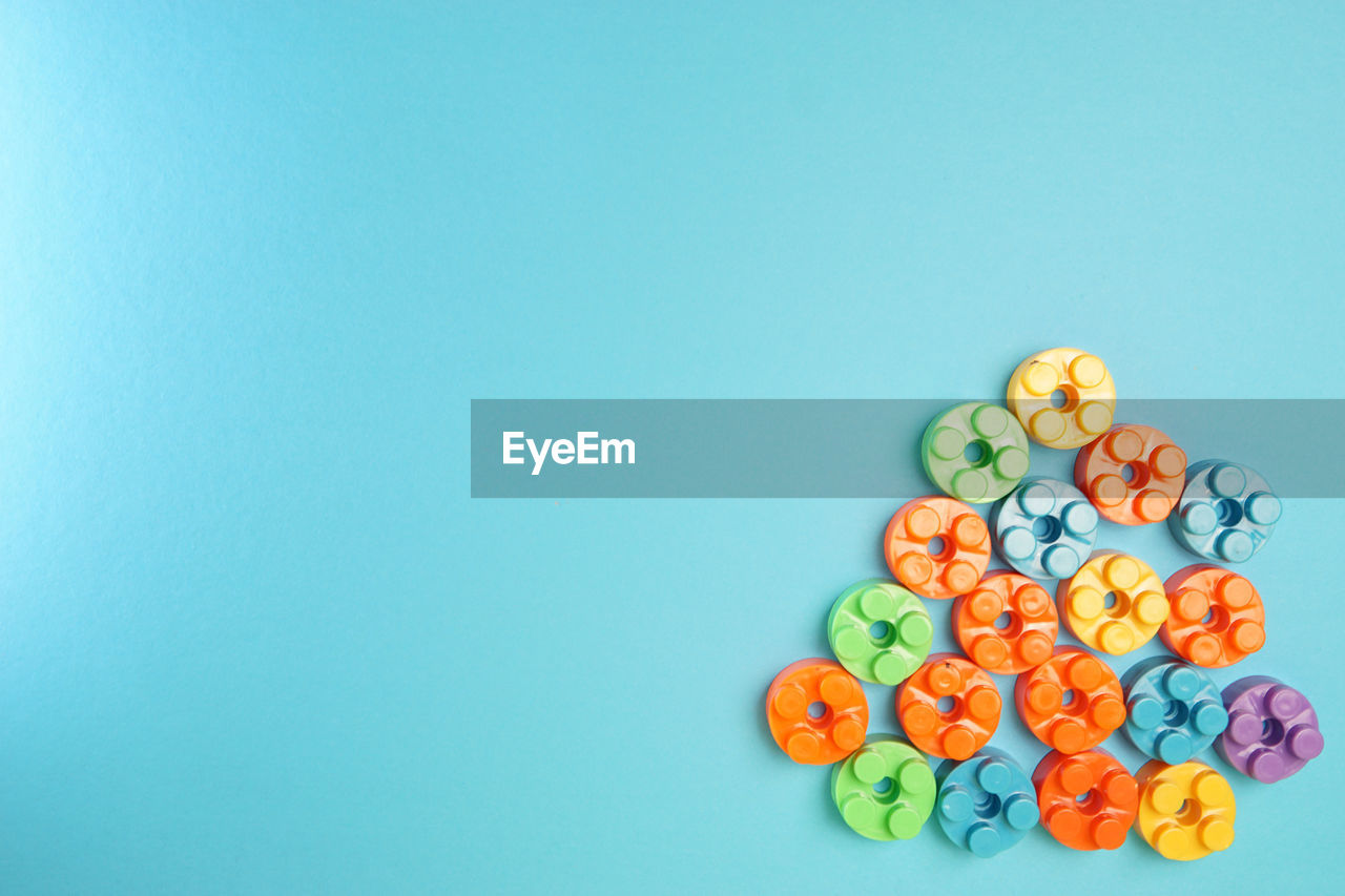 HIGH ANGLE VIEW OF MULTI COLORED CANDIES ON BLUE TABLE