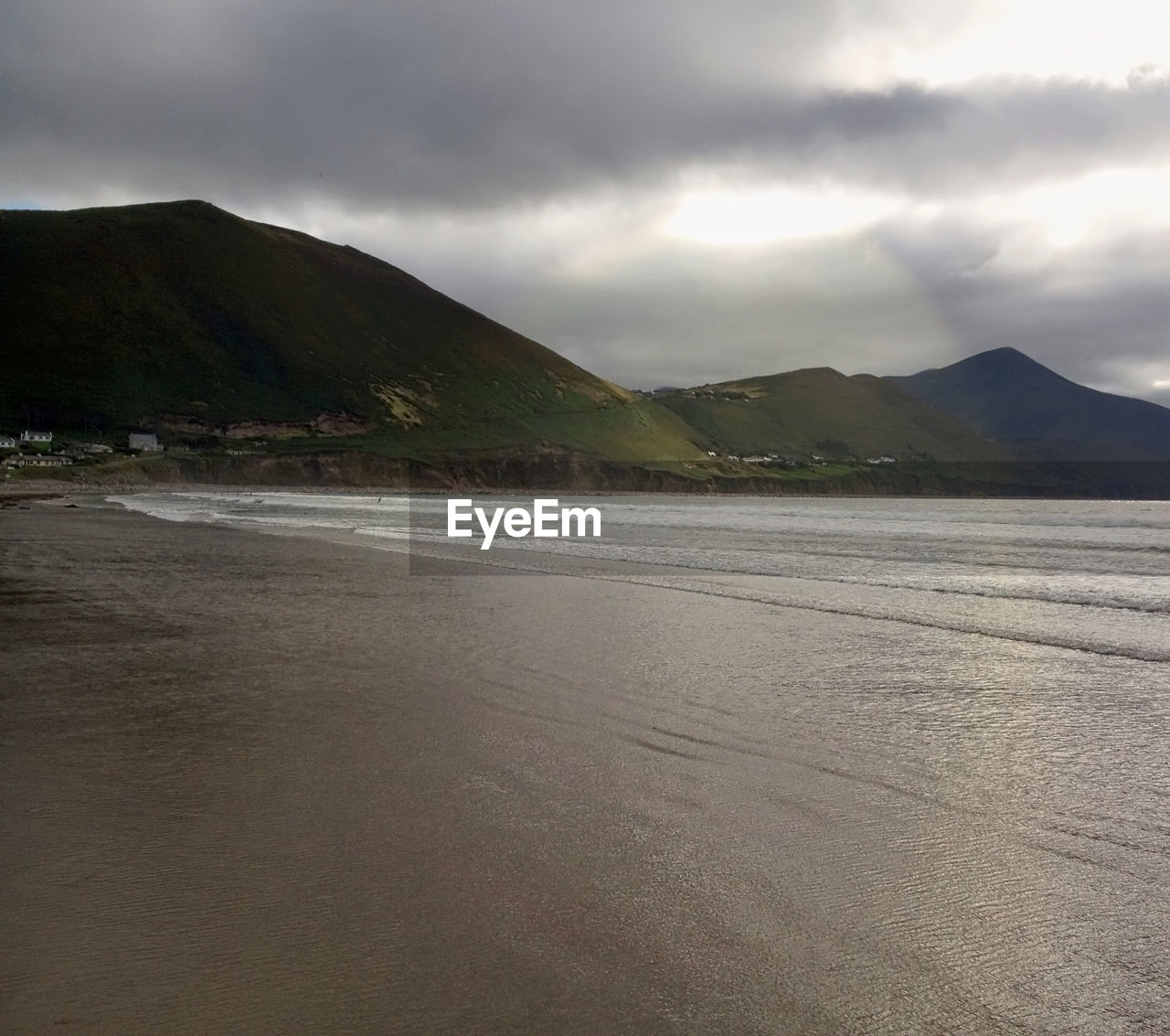 Scenic view of beach against cloudy sky