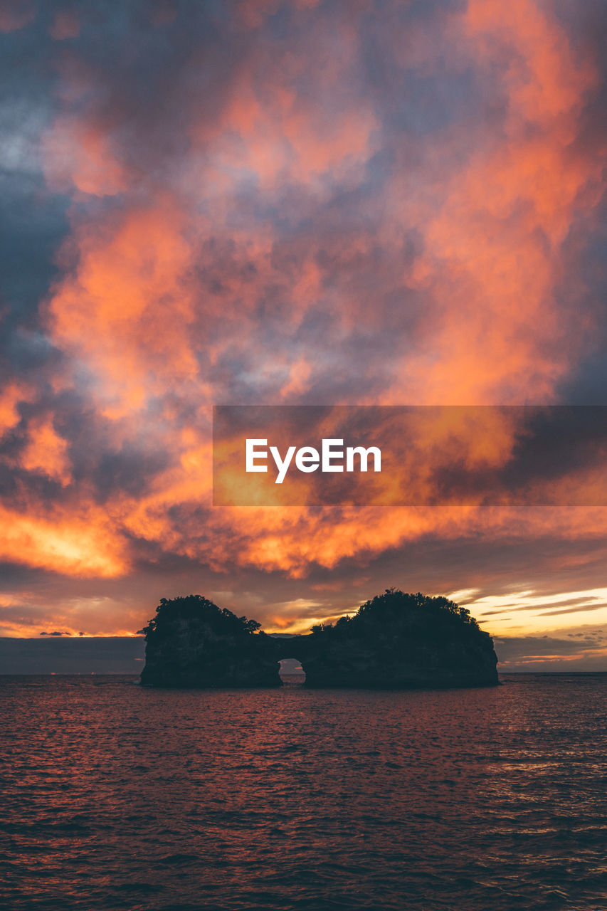 scenic view of sea against cloudy sky during sunset