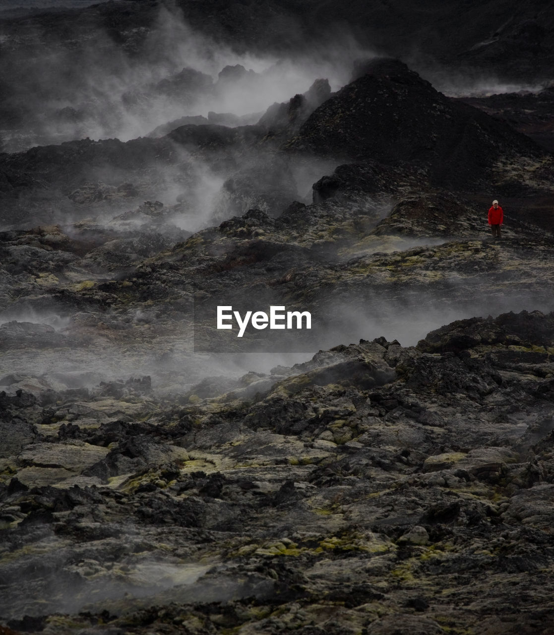 Woman hiking through the lava field at krafla volcano