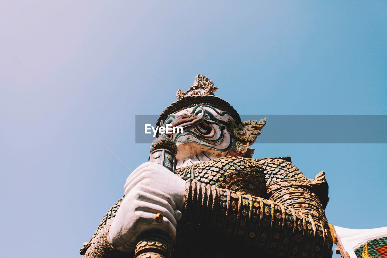 Low angle view of guardian statue against sky