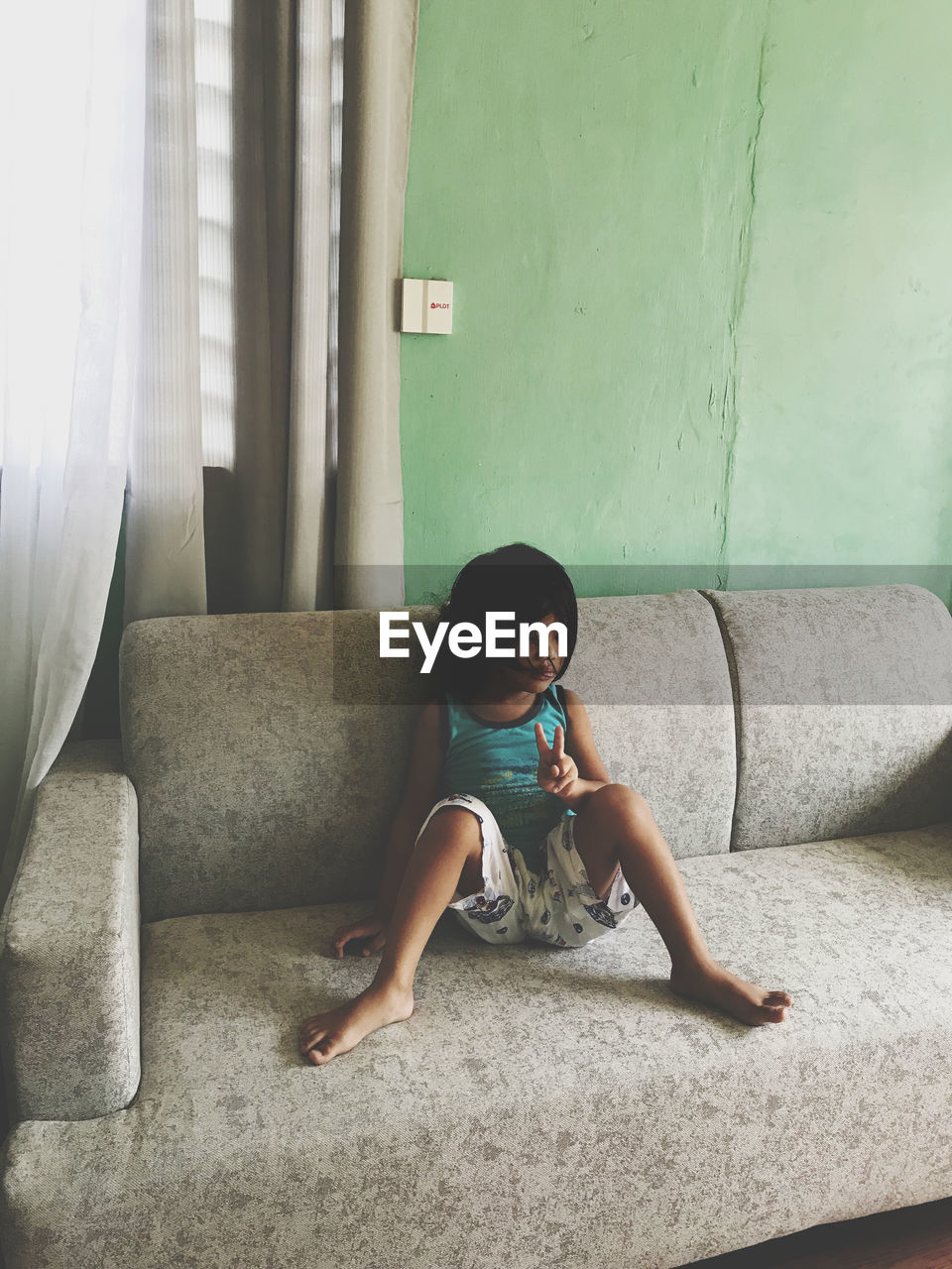 Young woman sitting on sofa at home