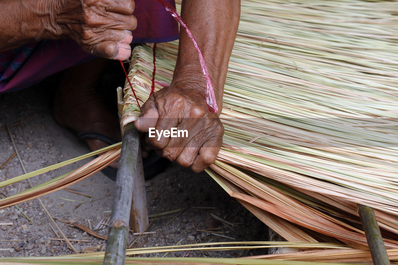 Man weaving straw at workshop