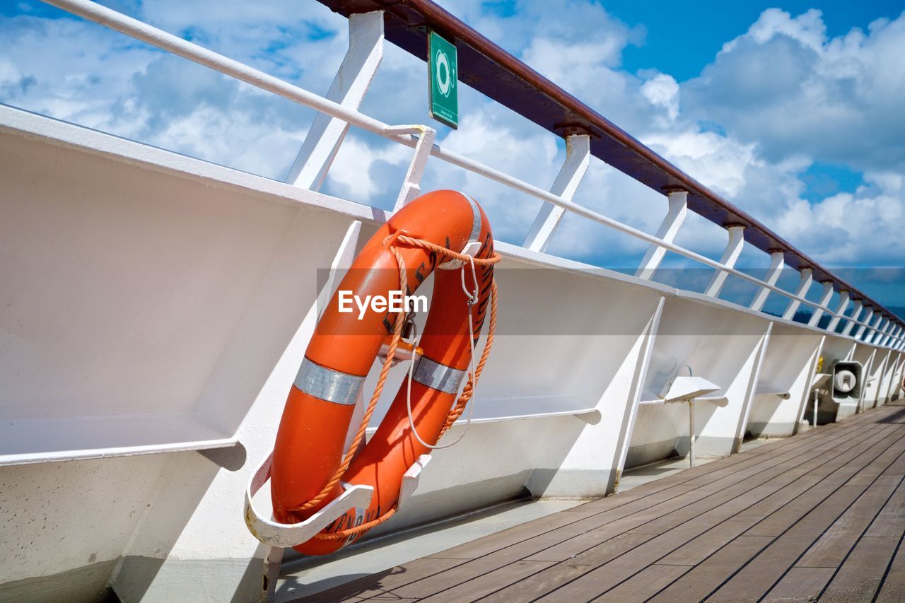 Life belt on boat against cloudy sky