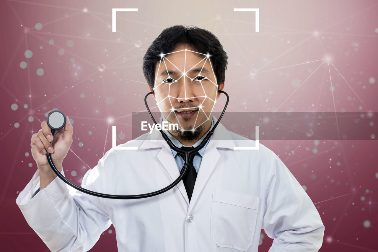 Digital composite image of doctor holding stethoscope against pink background
