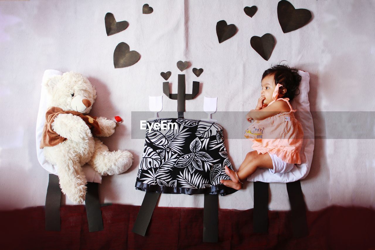 BOY STANDING WITH TOY ON BED