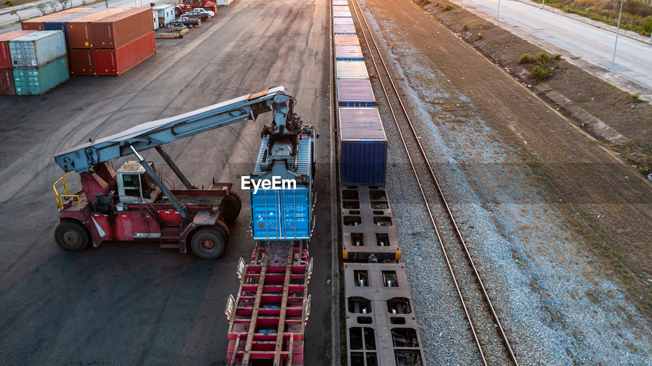 Aerial view crane loading container from container truck to container train, cargo train.