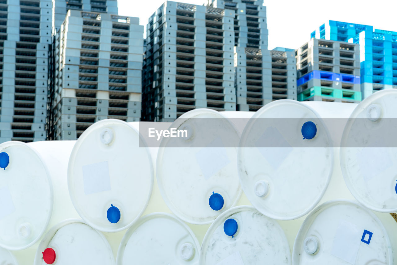 Old chemical barrels. empty white chemical drums stack on blur industrial plastic pallets. toxic