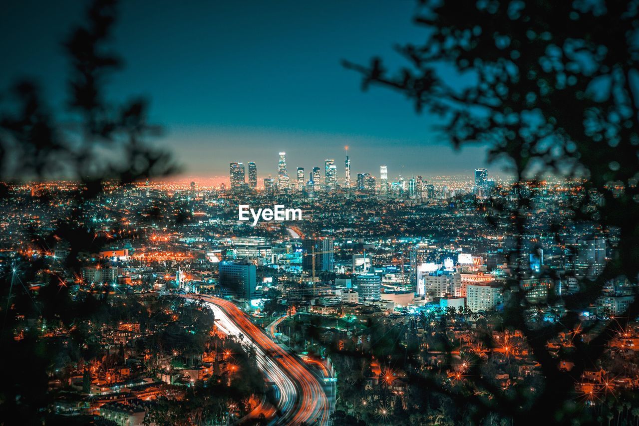 Illuminated cityscape against sky at night