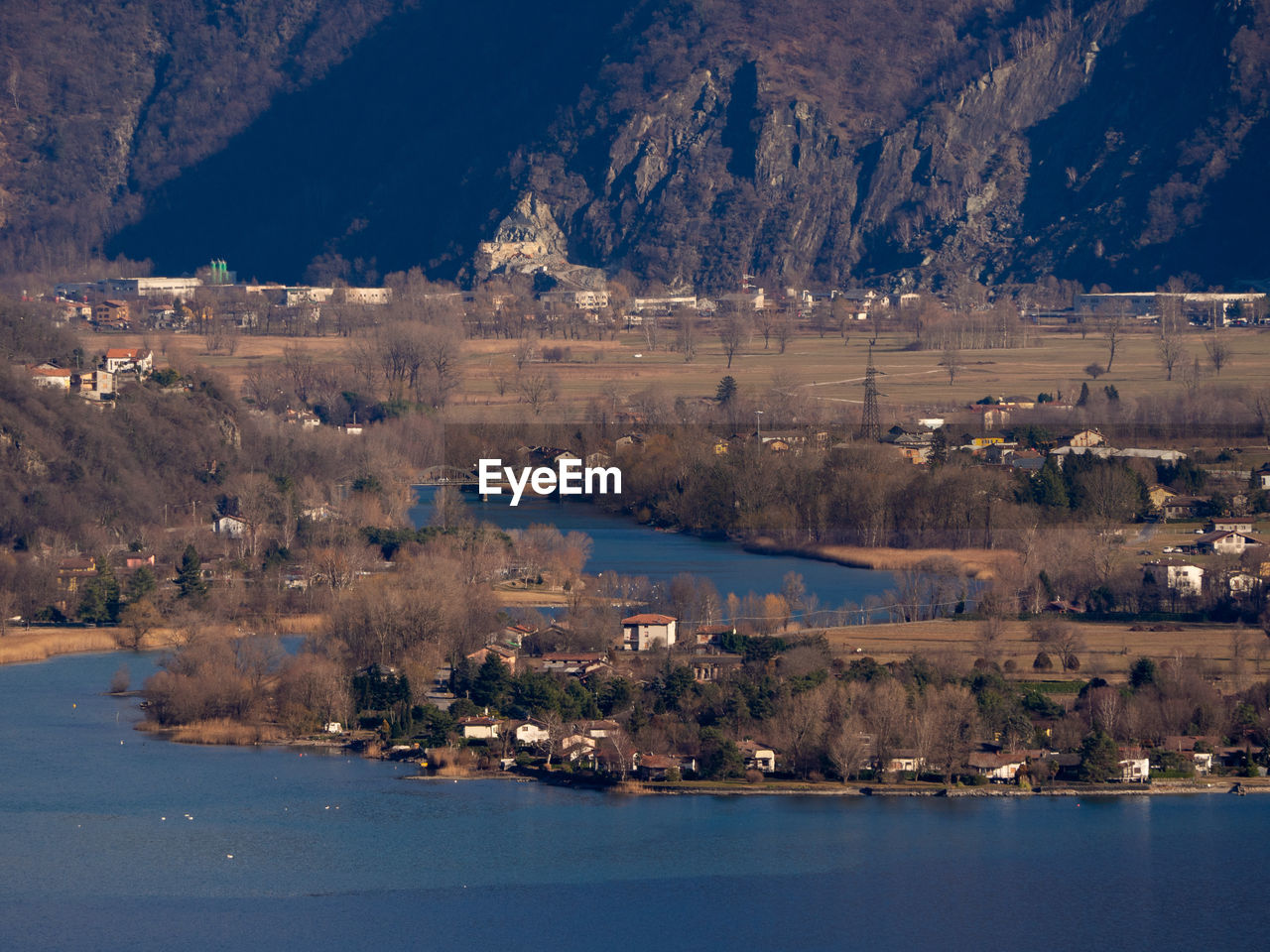 Scenic view of lake by city against mountain