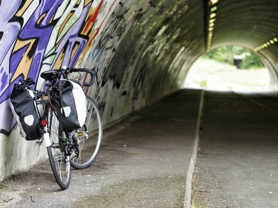 Bicycle parked by wall in tunnel
