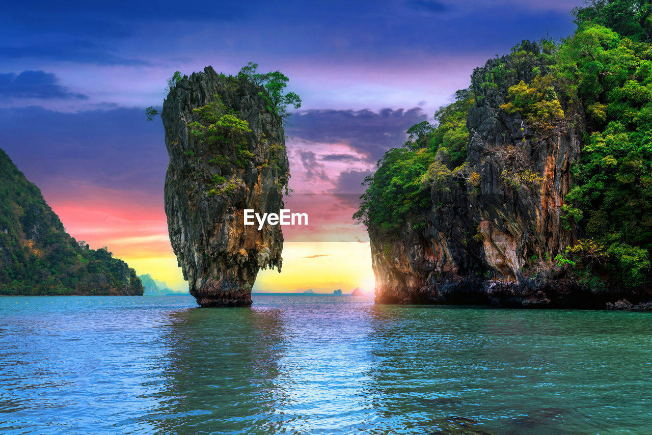 scenic view of rock formation in sea against sky