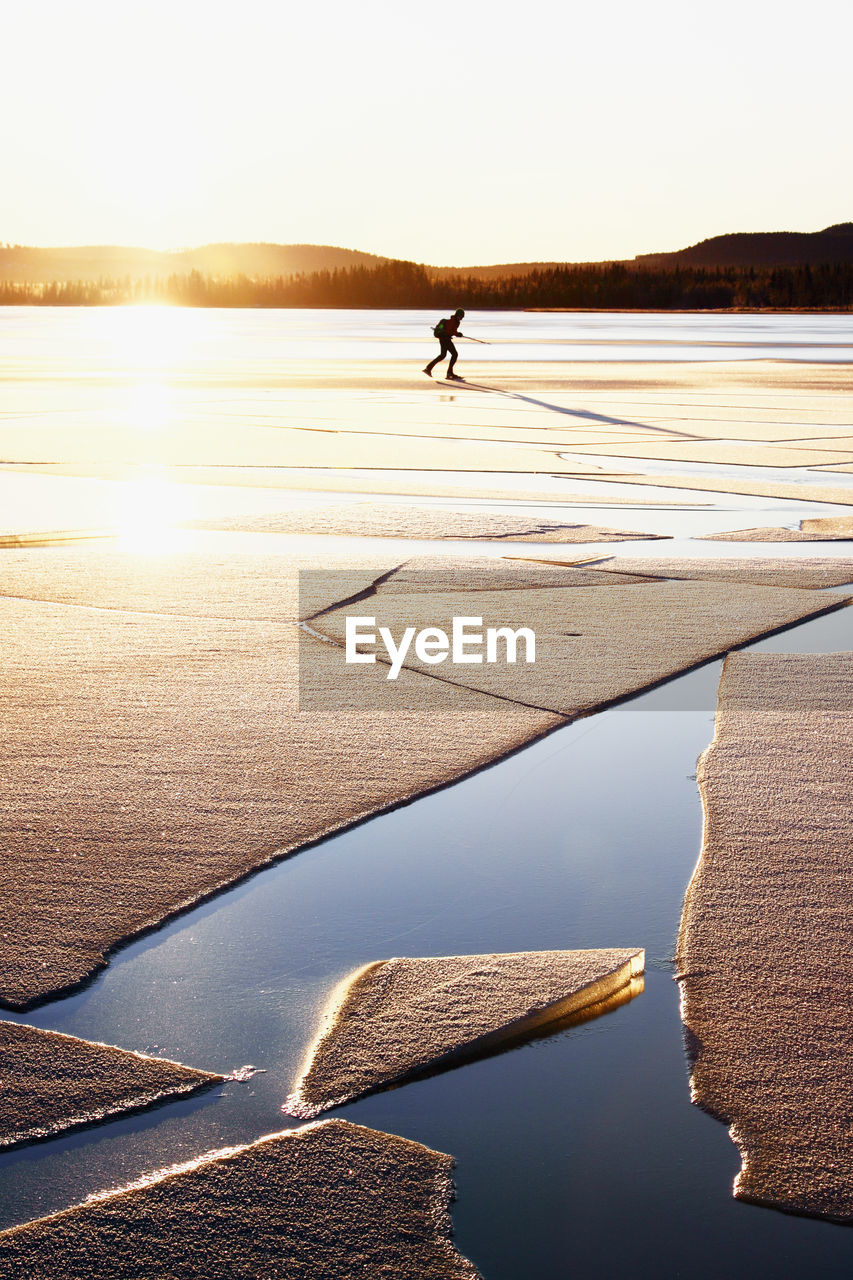 Woman ice-skating, ice floe on foreground