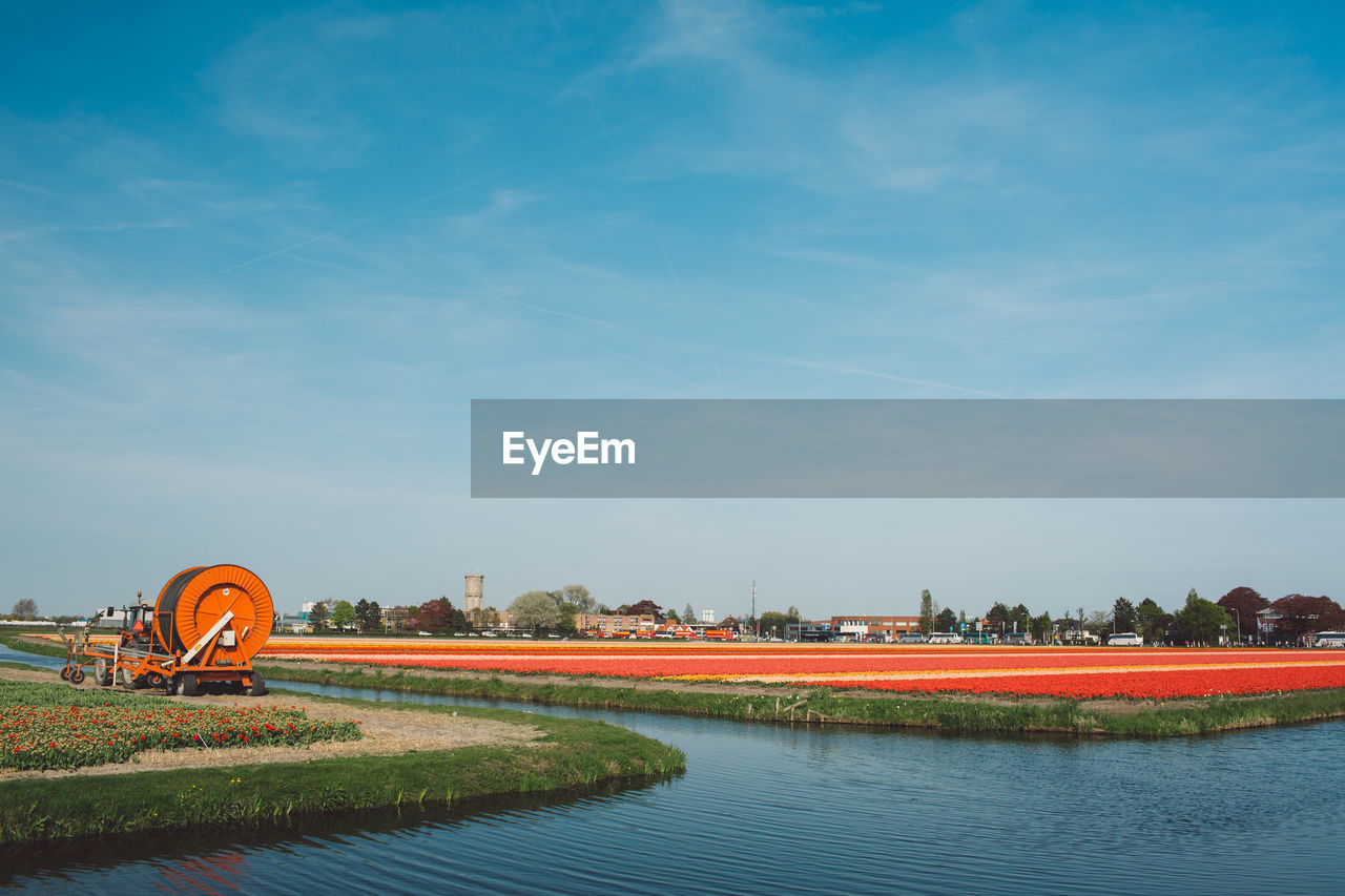 Scenic view of river and field against sky