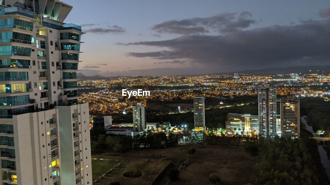 High angle view of illuminated street amidst buildings at night