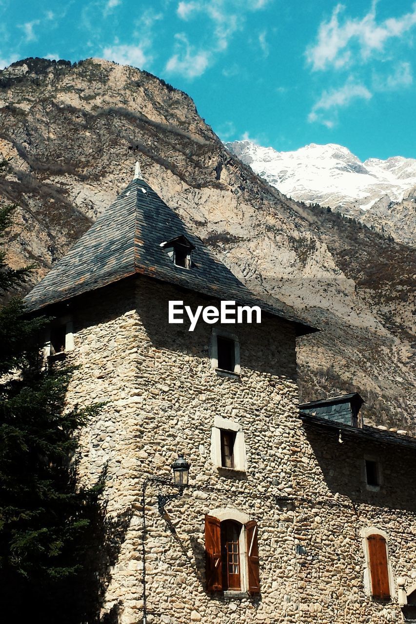 Low angle view of old house by mountain