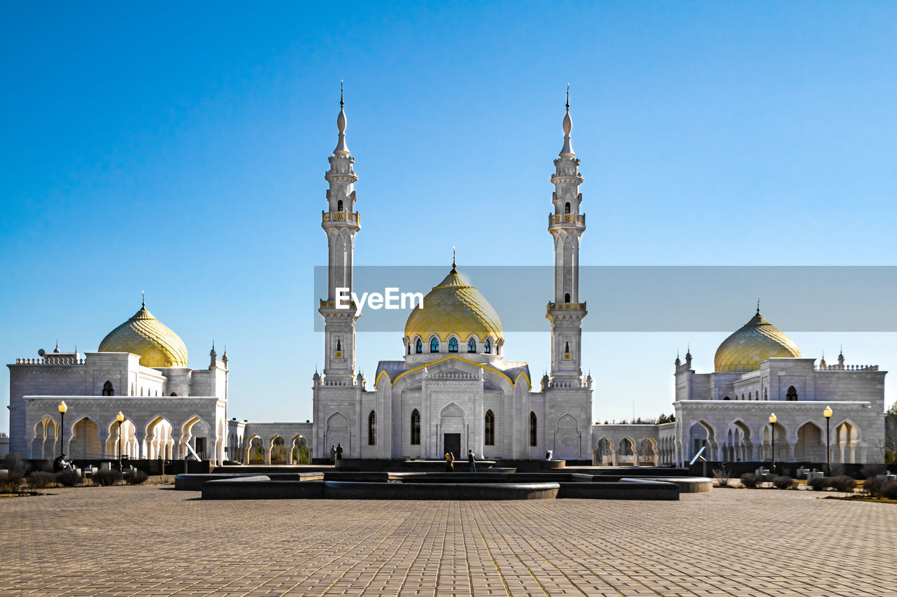 View of buildings against clear blue sky