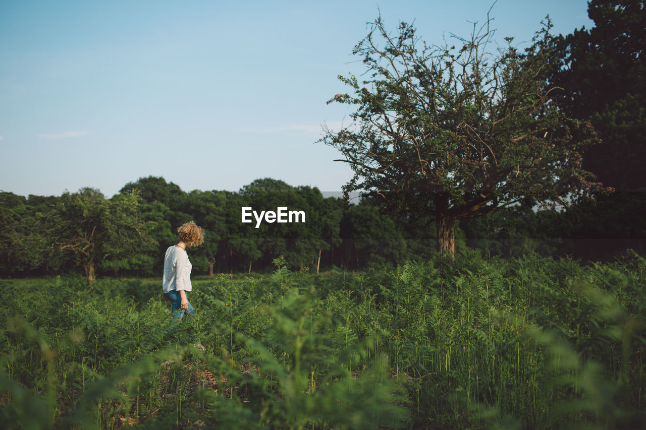 Woman standing on field against sky