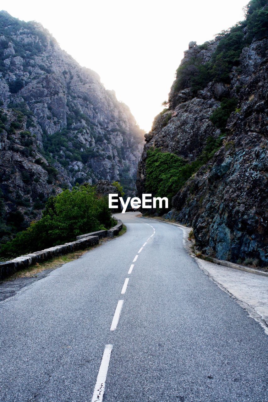 Road amidst mountains against clear sky