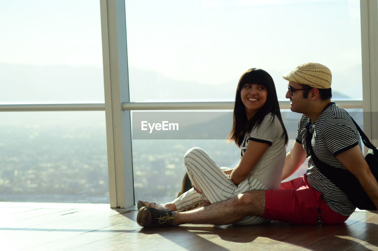 Couple bonding, sitting on floor, sky costanera, costanera center, chile