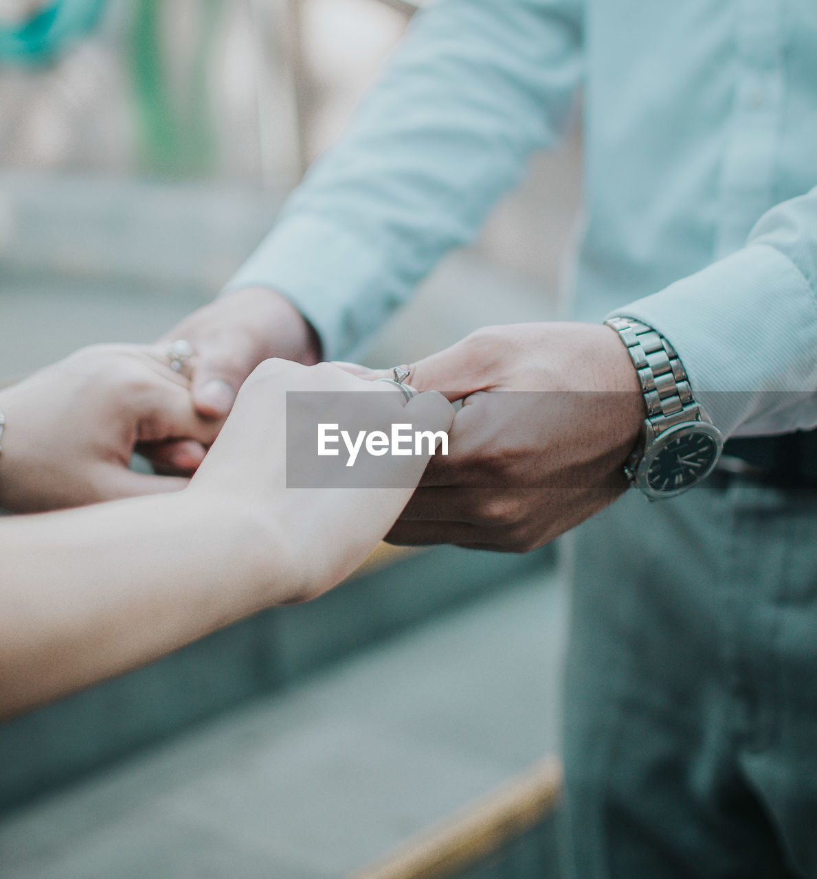 CLOSE-UP OF HANDS HOLDING PEOPLE