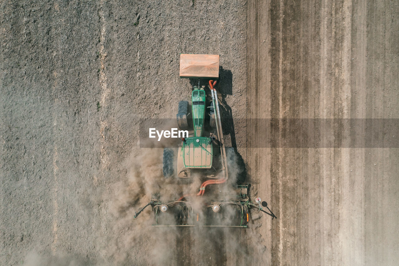 Agricultural tractor plows soil field for sowing , aerial top view from the drone . 