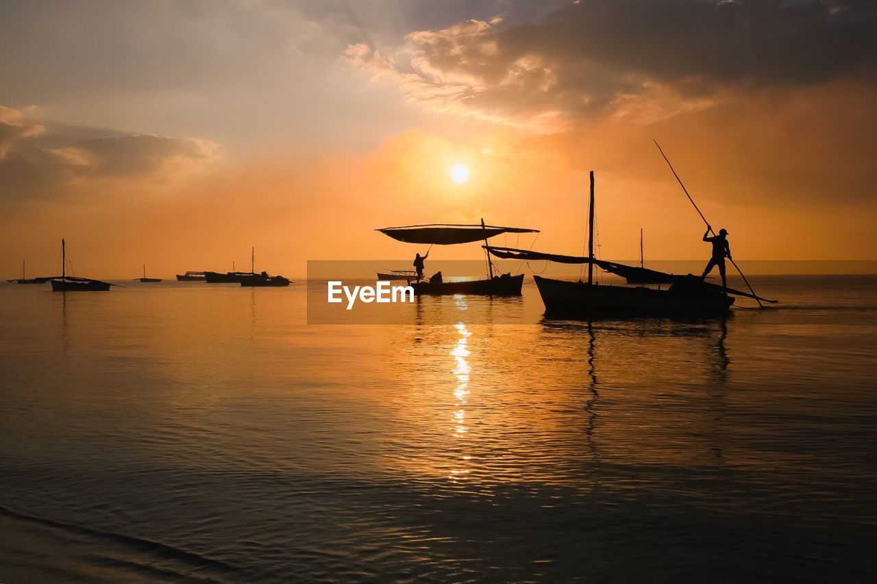 Silhouette ship in sea against sky during sunset