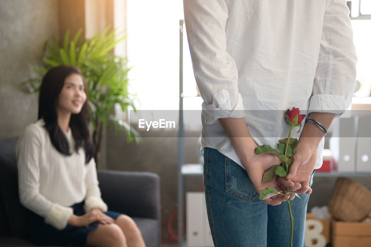 Man giving rose to girlfriend at office