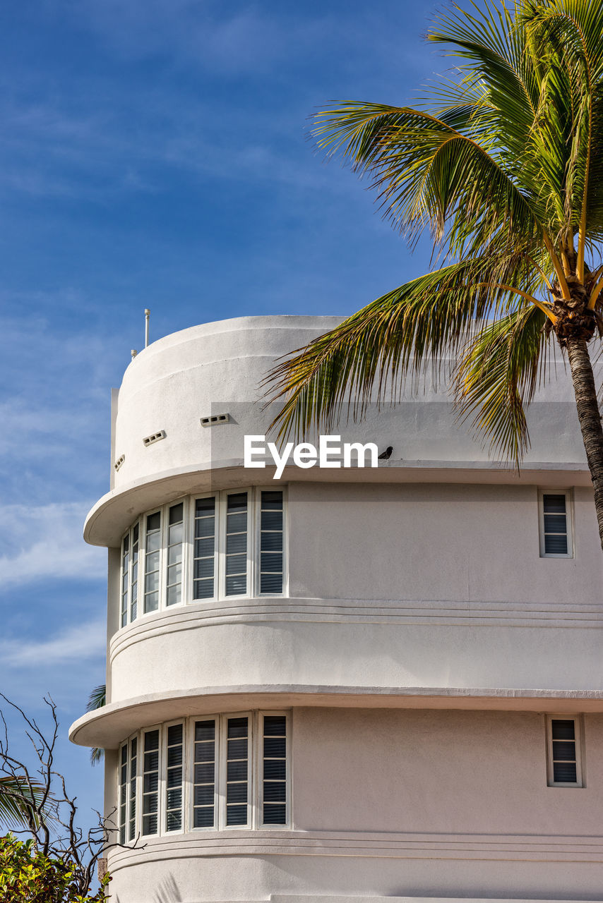 palm tree, tropical climate, architecture, building exterior, built structure, tree, building, sky, nature, plant, travel destinations, vacation, house, no people, outdoors, luxury, travel, residential district, wealth, blue, coconut palm tree, city, window, day, tower, tourism, trip, holiday, hotel, mansion, date palm tree, tourist resort
