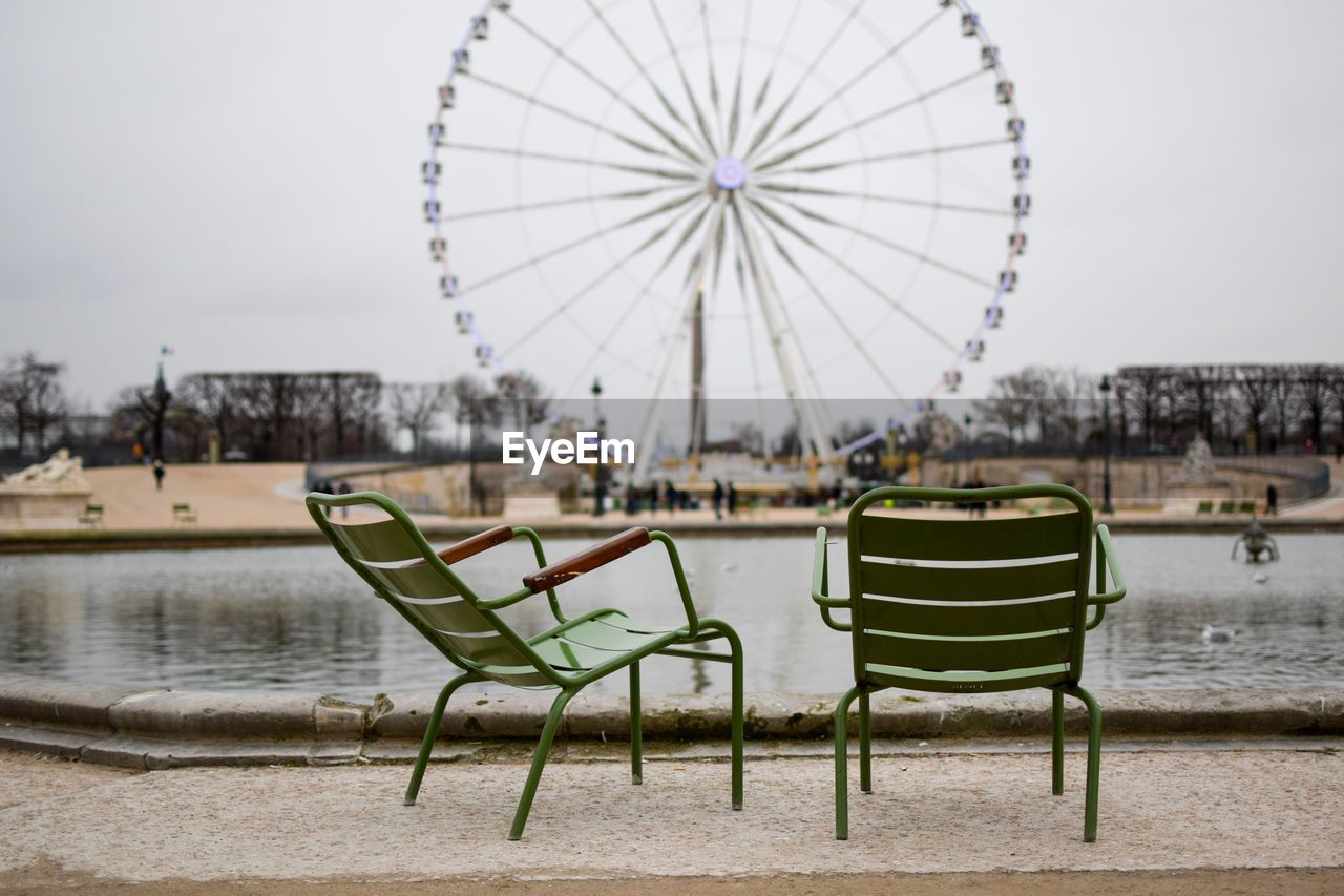 FERRIS WHEEL IN RIVER AGAINST SKY