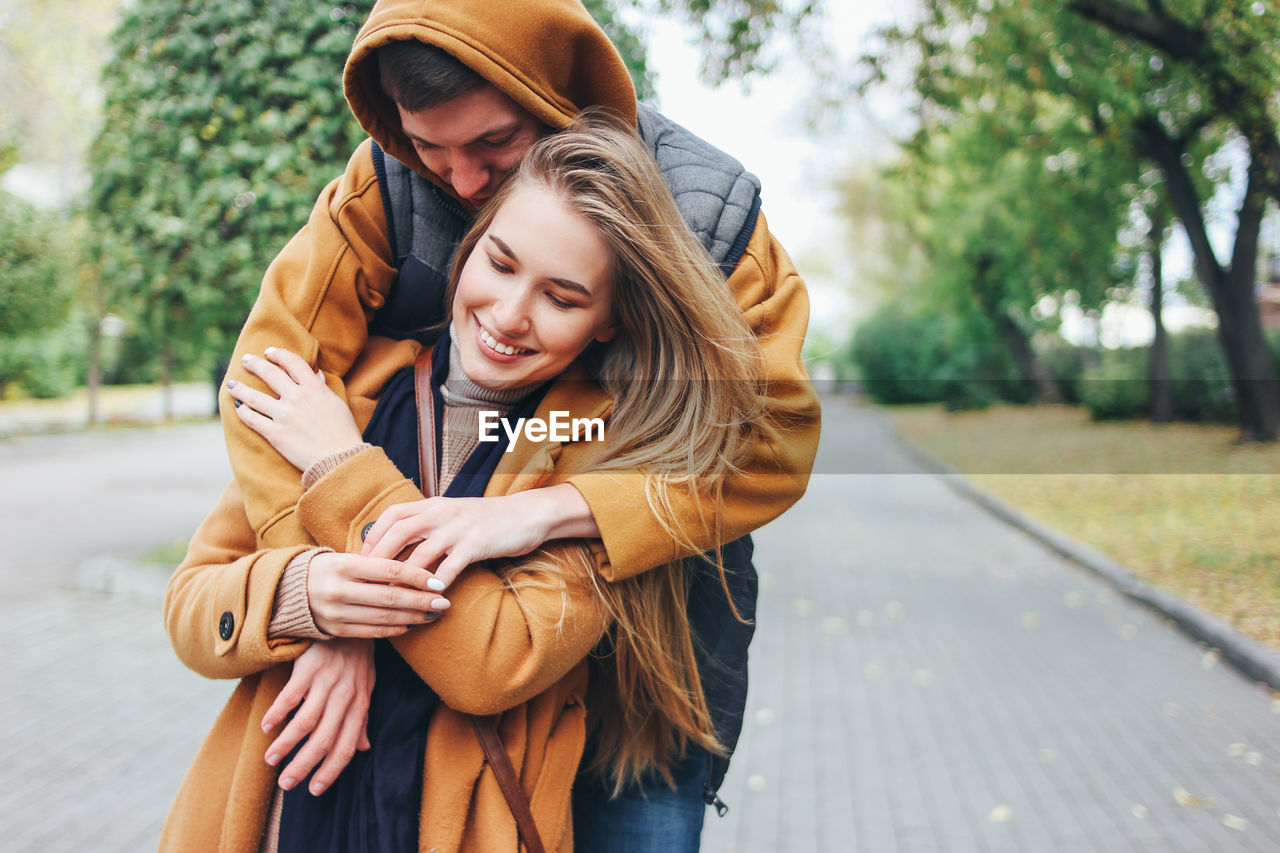 Couple wearing warm clothing while standing on footpath at park